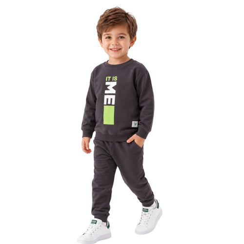 Smiling young boy wearing a “It Is Me” graphic sweatshirt with matching jogger pants 