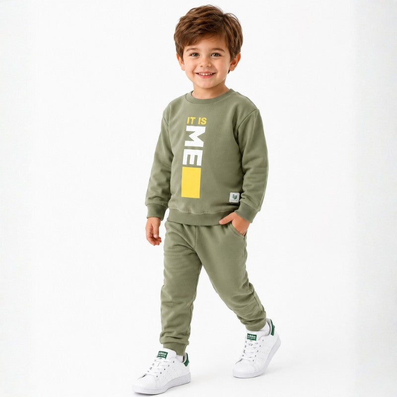 Smiling young boy wearing a “It Is Me” graphic sweatshirt with matching jogger pants 