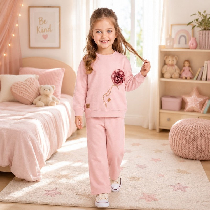 Girl wearing a rose appliqué sweatshirt with matching pink pants 