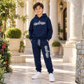 Boy wearing a navy blue graphic hoodie and matching joggers 